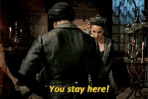 a man and a woman are standing next to each other and the woman is saying " you stay here "