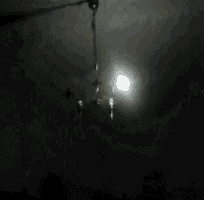 a street light is lit up in the dark with smoke coming out of it