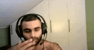 a man without a shirt is wearing headphones and a microphone .