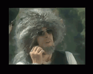 a man wearing a wig and sunglasses is talking on a phone