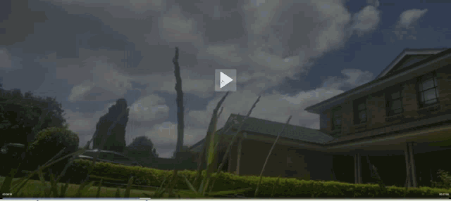 a video of a house with a blue sky and clouds