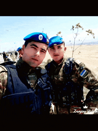 two soldiers are posing for a picture and the words zenjoy video are on the bottom