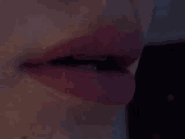 a close up of a woman 's lips with red lipstick and a black eye .