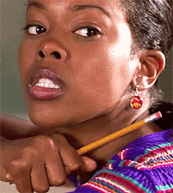 a close up of a woman holding a pencil