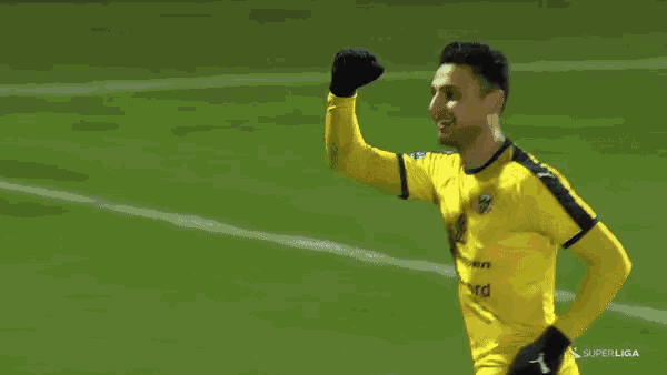 a soccer player wearing a yellow shirt that says " superliga " on it