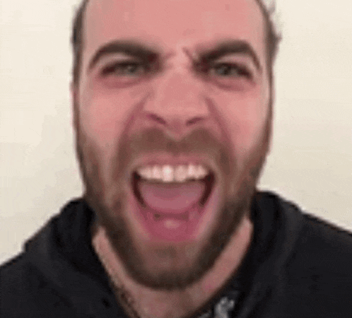 a man with a beard is screaming with his mouth open .