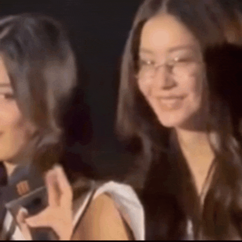 two women wearing glasses are standing next to each other and smiling
