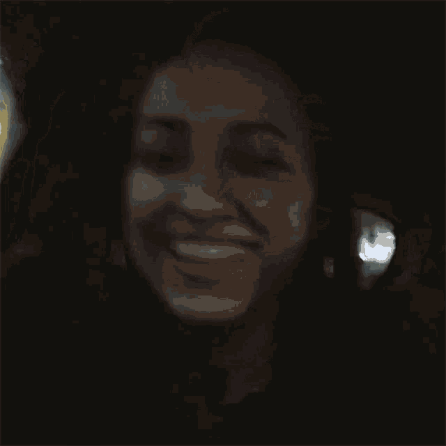 a woman is smiling while sitting in a car