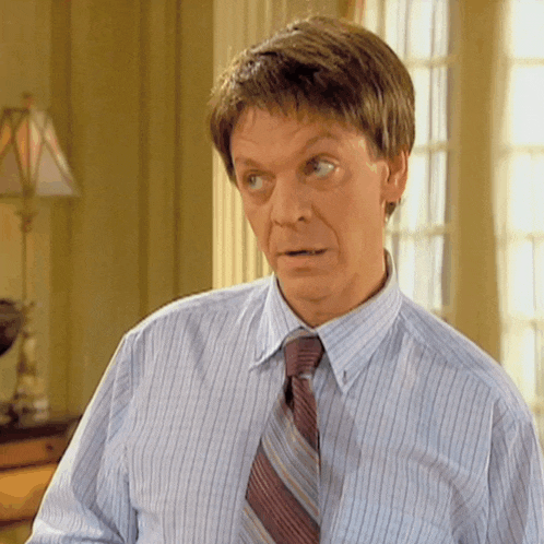 a man wearing a striped shirt and tie looks very surprised
