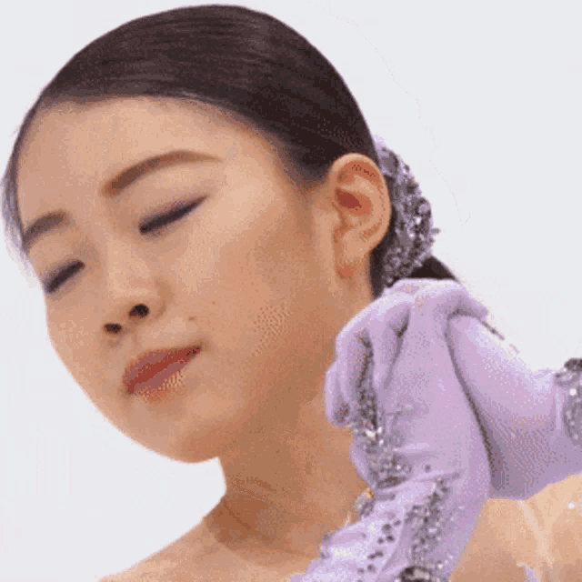 a woman wearing purple gloves looks down at something