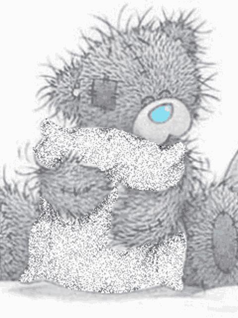 a teddy bear is holding a pillow and a piece of paper in its paws .