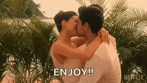 a man and a woman are kissing on a beach .