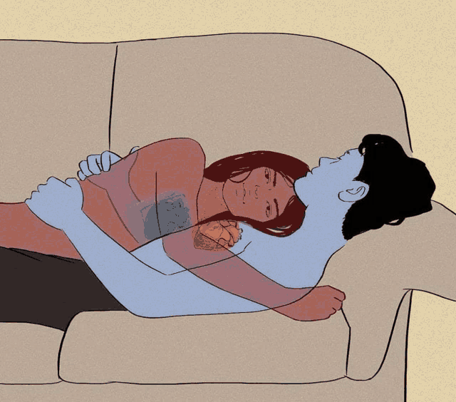 a man and woman laying on a couch hugging each other