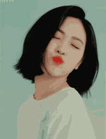 a woman with short hair and red lips is smiling with a heart in the background