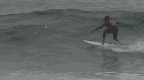 a surfer is riding a wave on top of a surfboard in the ocean .