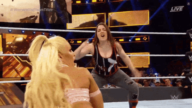 two women are wrestling in a ring with the words live on the screen