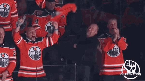 a group of edmonton oilers hockey players celebrate a win