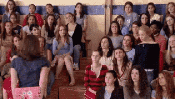 a woman is standing in front of a crowd of women