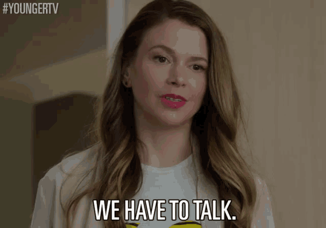 a woman says we have to talk while wearing a smiley face shirt