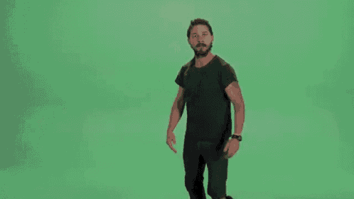 a man is dancing in front of a green screen .