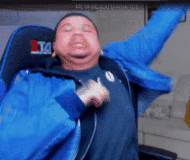 a man in a blue jacket is sitting in a chair with his arms outstretched and the word meta on the back