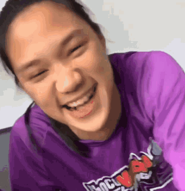 a woman wearing a purple shirt with the word brooklyn on it is smiling
