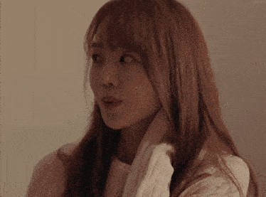 a woman with long brown hair is wearing a white sweater and scarf