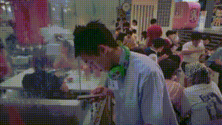 a man wearing headphones is standing in front of a crowd of people in a restaurant .
