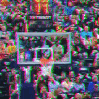 a basketball player is going for a basket in front of a crowd of people .
