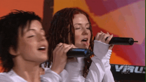 two women are singing into microphones in front of a keyboard that says nbc