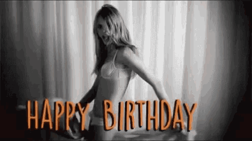 a woman in lingerie is dancing in front of a window with the words `` happy birthday '' .