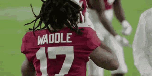 a football player wearing a red jersey with the number 17 on the back