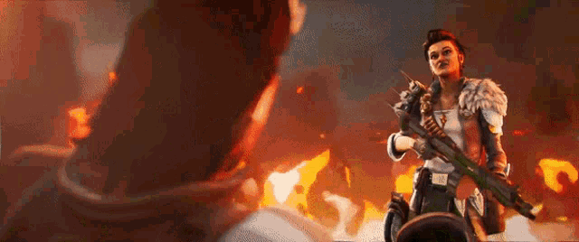 a woman is holding a gun in front of a fire while a man looks on .