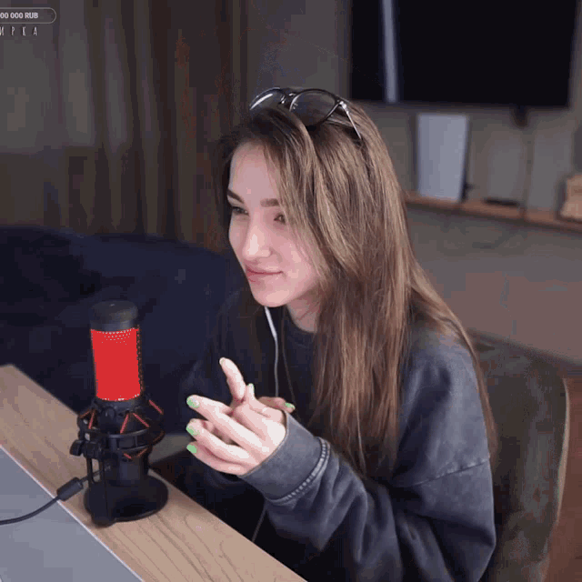 a woman sitting in front of a red and black microphone with a popup that says ' 00 000 rub ' on it