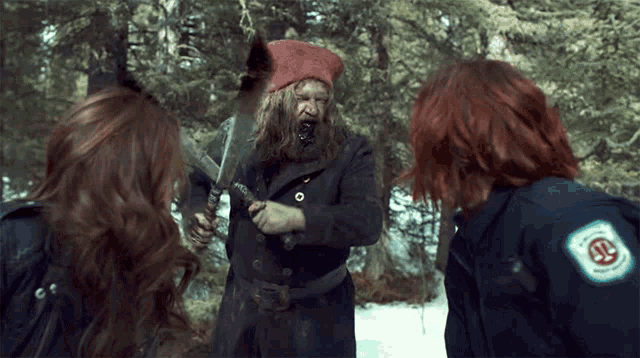 a man in a red hat is holding a sword and two women are standing around him