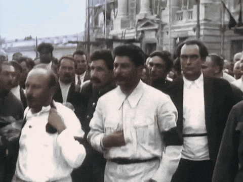 a man with a mustache is walking in a crowd of men