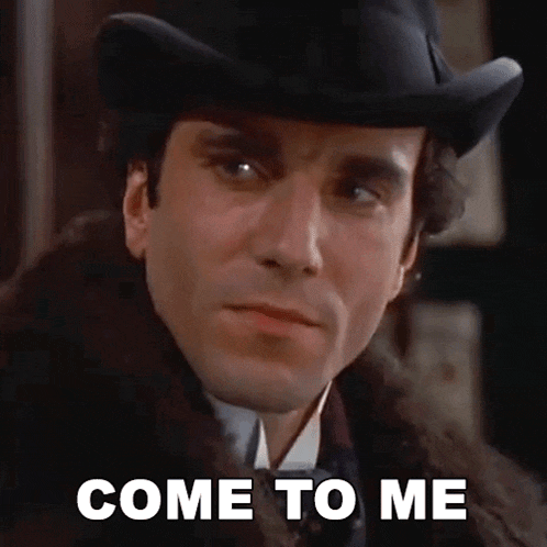 a man wearing a hat and a fur coat is looking at the camera and saying `` come to me '' .