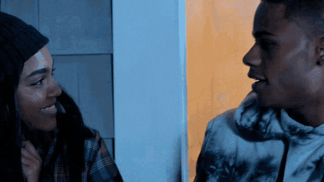 a man and a woman are standing next to each other and smiling at each other .