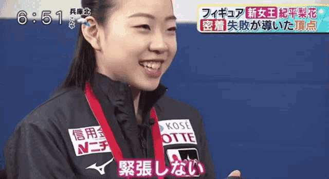 a woman wearing a black jacket with a medal around her neck that says kose