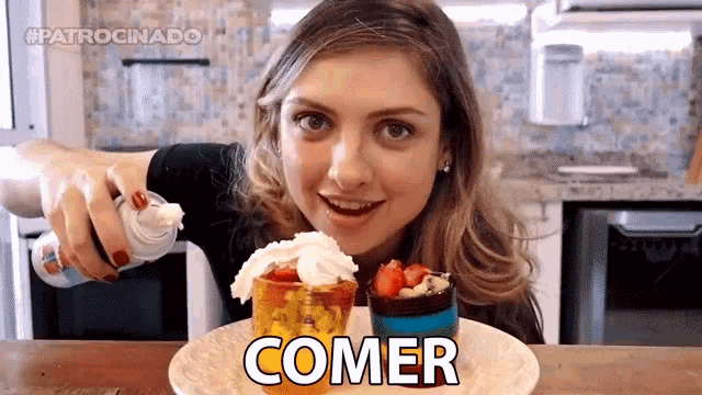 a woman eating a dessert with the word comer written on the plate
