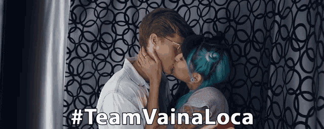 a man and woman kissing in front of a curtain with #team vainaloca written on the bottom