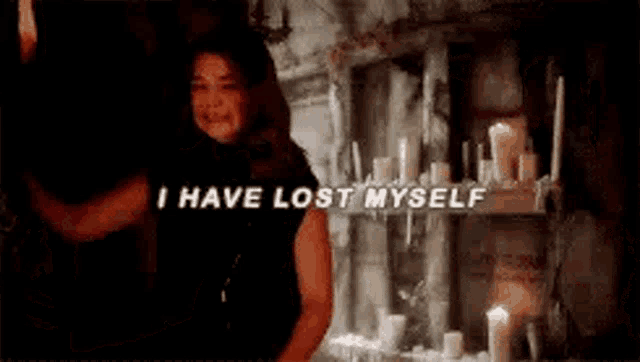 a woman is crying in a dark room with candles on a shelf and says `` i have lost myself '' .