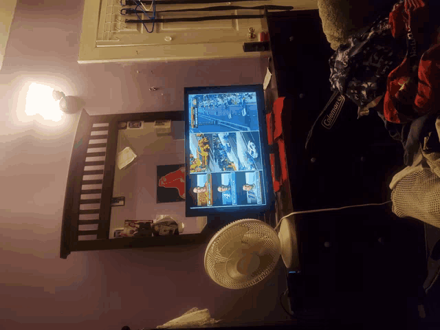 a coleman fan sits on a dresser next to a tv
