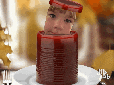 a child 's face is sticking out of a red can on a white plate