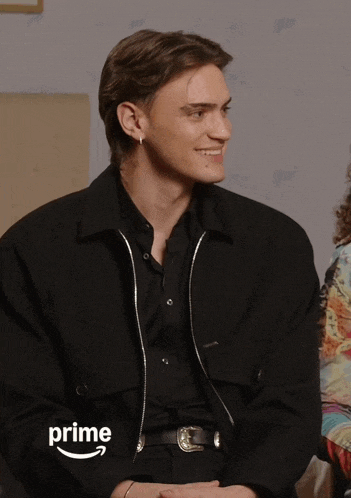 a man wearing a black jacket with the word prime on the bottom right