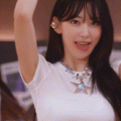 a close up of a woman wearing a white shirt and a necklace .