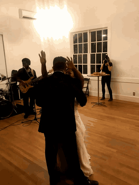 a bride and groom dance in front of a band