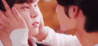 a man is touching another man 's face with his hand .