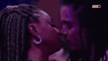a man and a woman are kissing in front of a globeplay logo