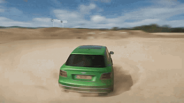 a green bentley is driving through the sand